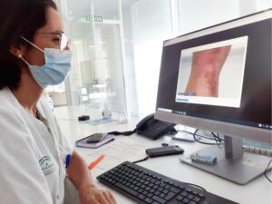 doctora Amalia Serrano, dermatóloga visionando una imagen de teleconsulta por dermatitis atópica